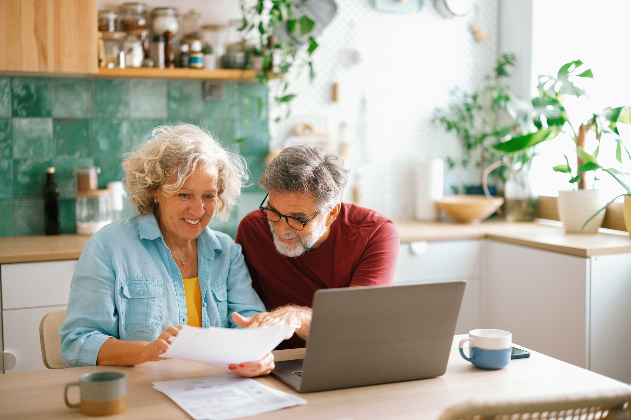 Senior couple managing making a Will on laptop